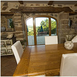 Salle à manger avec vue sur la cours principale au travers d'un porche en pierre